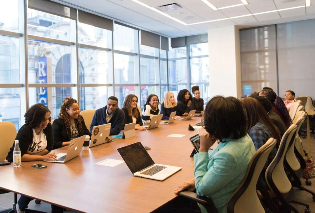 lots of people sitting around a table in meeting room