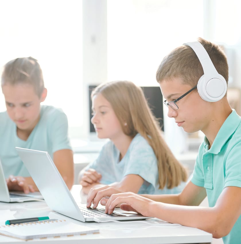 One of youthful classmates in headphones looking at laptop display